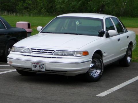 1997 Mercury Grand Marquis - White Ford Crown Victoria parked in a lot, with another vehicle to its left. Wisconsin plate 605-NBG.