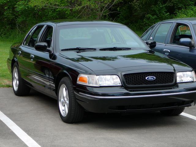 Black sedan with a honeycomb grille and chrome trim, parked next to another dark sedan