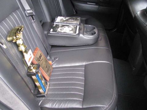 2003 Mercury Marauder - Trophies are displayed on the rear seat of a car, next to a center console with cup holders.