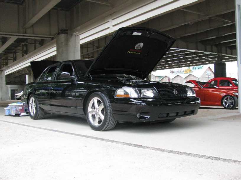 Black 2003 Mercury Marauder with hood and trunk open, parked under a bridge