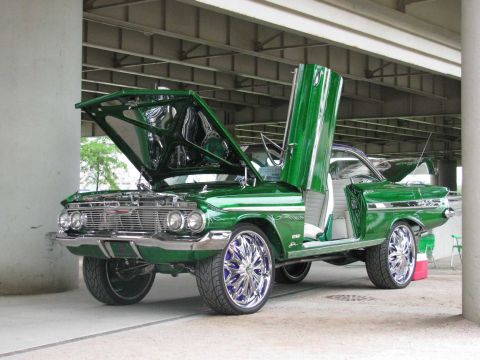 2003 Mercury Marauder - Customized 1960 Chevrolet Impala with unique door modifications and large chrome wheels on display.