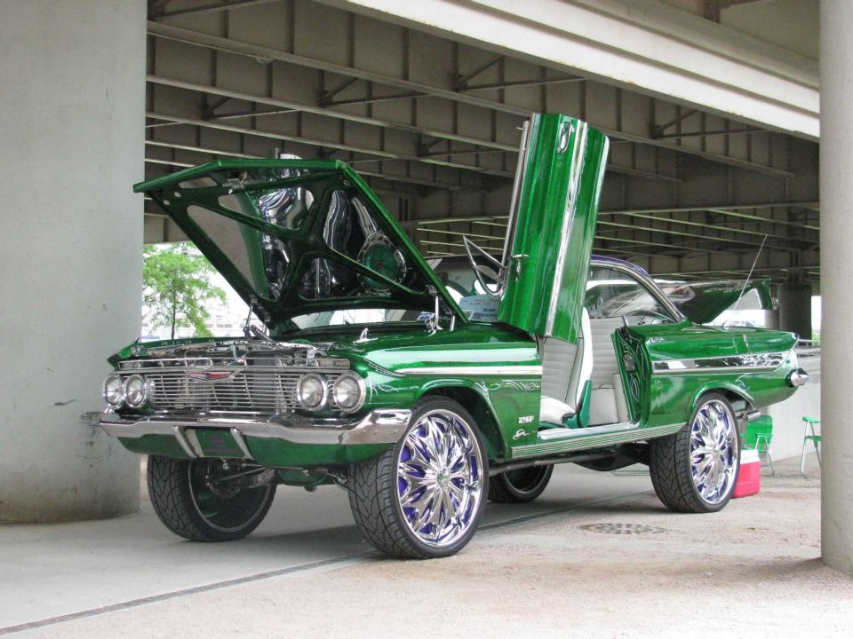 Green 1960 Chevrolet Impala custom with suicide doors and large chrome wheels