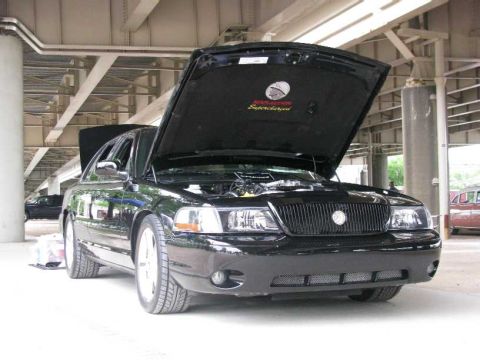 2003 Mercury Marauder - A black Mercury Marauder is parked under an overpass with its hood open, revealing the engine compartment.