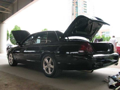 2003 Mercury Marauder - This black 2003 Mercury Marauder is shown with its hood and trunk open, revealing its engine bay and cargo space.