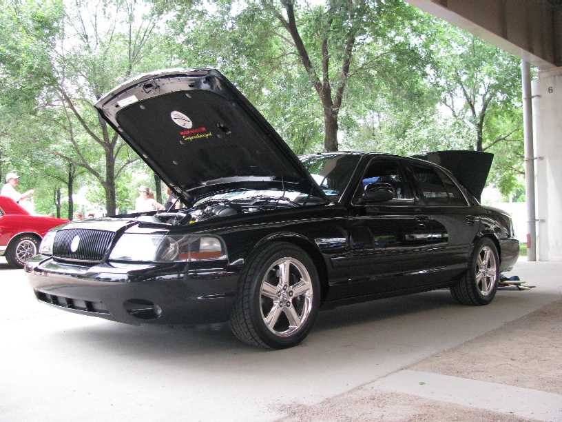 2003 Mercury Marauder with hood open, parked under a structure. Another car is visible to the left