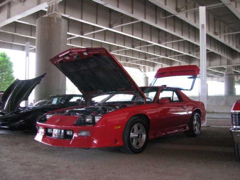 2003 Mercury Marauder - A red coupe with its hood and trunk open is parked under a bridge, with other vehicles nearby.