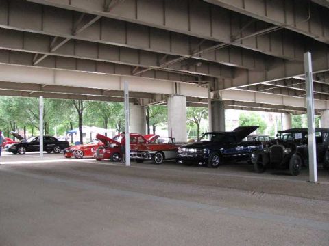 2003 Mercury Marauder - A car show features multiple vehicles parked outdoors under a bridge structure.
