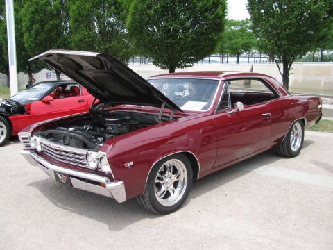 2003 Mercury Marauder - A maroon 1967 coupe is displayed with its hood open, revealing the engine compartment. A red car is parked behind it.