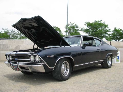 2003 Mercury Marauder - A dark blue 1969 Chevrolet Chevelle coupe is shown with its hood open, displaying its engine bay.