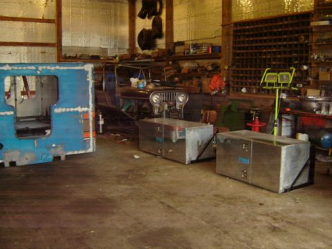 1992 Ford Bronco - Photograph of a workshop interior with project vehicles and fabricated boxes, not a technical document.