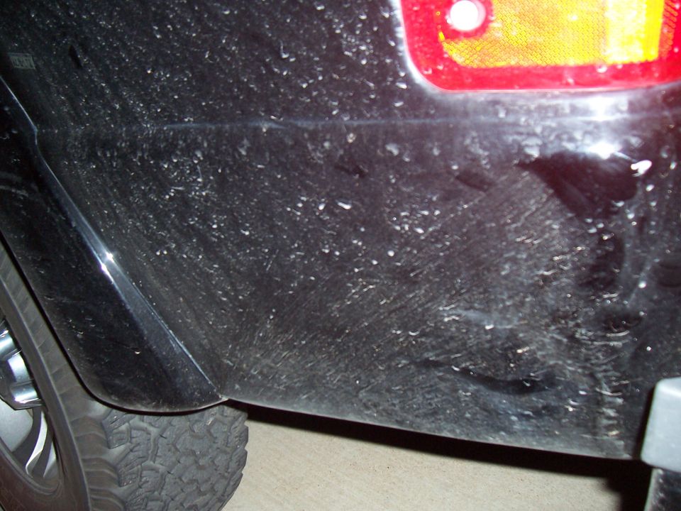 Close-up of a dark vehicle body panel and mud flap
