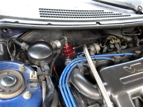 1993 Ford Probe - A close-up view of the engine bay of a blue vehicle, focusing on various aftermarket fuel system components including a red fuel pressure r…