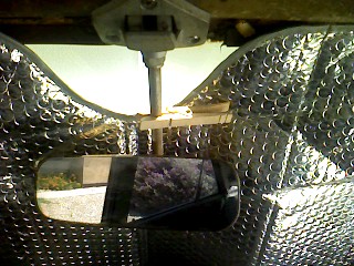 1965 Ford Ranchero - The interior view shows a rearview mirror mounted on a modified bracket attached to the windshield header. The surrounding area is covered…