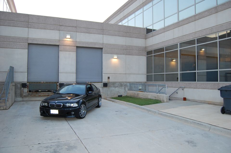 Black 2002 BMW M3 parked in front of a modern building