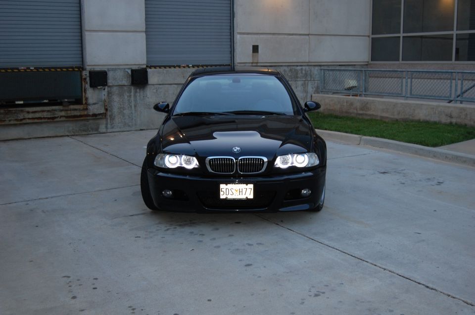 Black 2002 BMW M3 front view with headlights on
