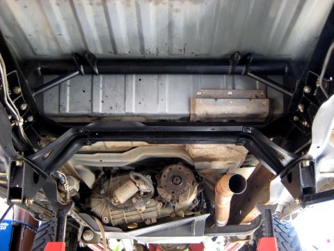 1996 Ford Bronco - Close-up of the rear suspension and drivetrain components from underneath.