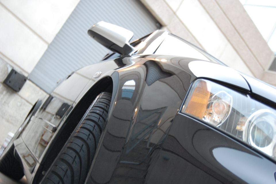 Black car front fender and headlight, low angle view