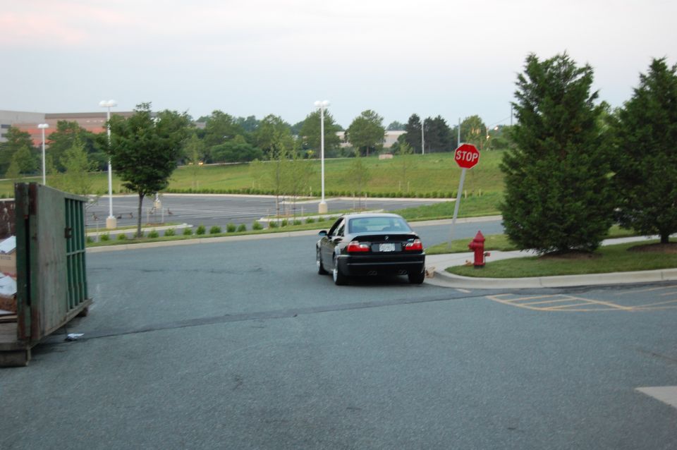 Black BMW E46 M3 coupe rear view in empty office park parking lot at dusk