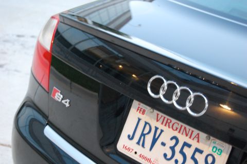 2002 BMW M3 - The rear of a black Audi S4 is shown, with its signature four rings emblem and S4 badge visible.