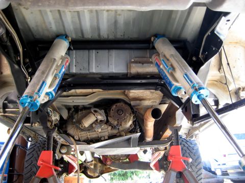 1996 Ford Bronco - Underneath view of a vehicle's rear suspension, showing dual Fox shocks and the transfer case.