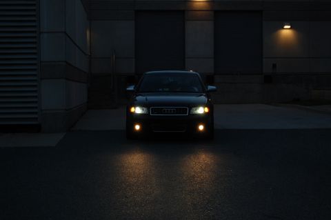 2002 BMW M3 - Front view of a black Audi A4 sedan at night, headlights illuminated.