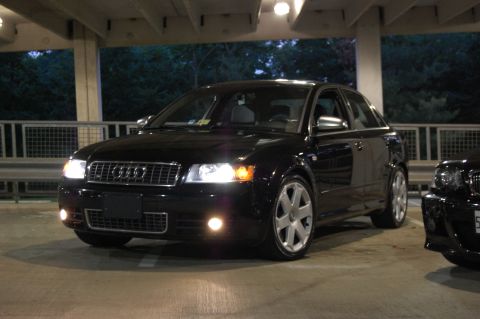 2002 BMW M3 - A black Audi sedan is parked in a garage, with another vehicle partially visible to the right. The 'SUPERMOTORS' watermark is present at th…