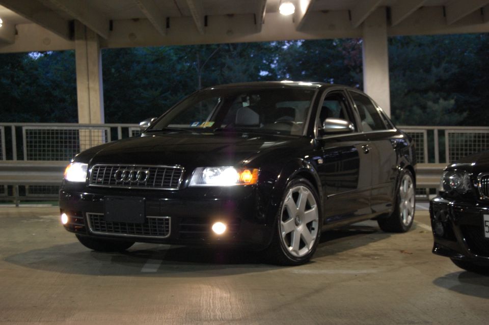 Black Audi sedan, front 3/4 view, with visible 'SUPERMOTORS' text