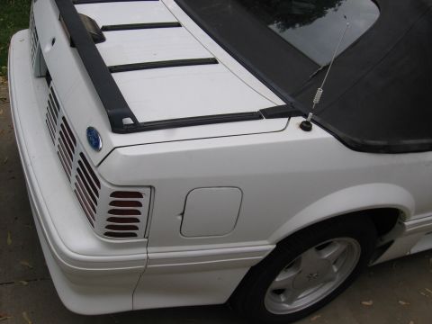 1990 Ford Mustang - Rear view of a white 1990 Ford Mustang convertible, showing the taillights and trunk lid.