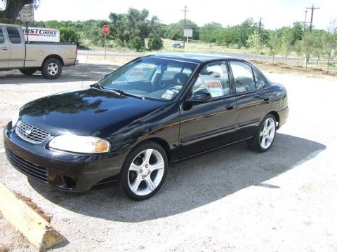 2000 Nissan Sentra - A black 2000 Nissan Sentra sedan is parked on a lot with a 'For Sale' sign in the window.