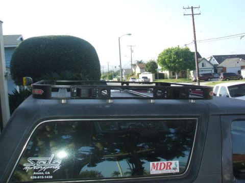 1988 Ford Bronco - A roof rack is mounted on the top of a 1988 Ford Bronco, seen from the side.
