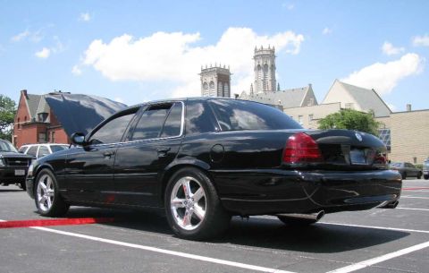 2003 Mercury Marauder - Black 2003 Mercury Marauder parked in lot with hood up, showing other cars and architecture.
