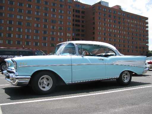 Light blue 1957 Chevrolet Bel Air coupe with a white roof, chrome trim, and aftermarket wheels