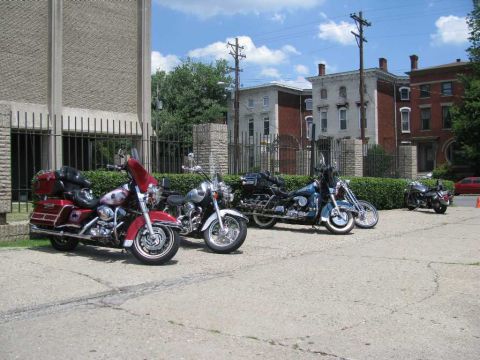 2003 Mercury Marauder - A group of motorcycles are parked in a lot on a sunny day, with buildings visible behind them.