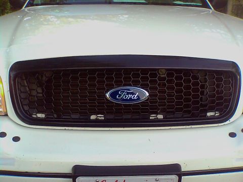2000 Ford Crown Victoria - Front view of a white Ford Crown Victoria showing the grille and Ford emblem.