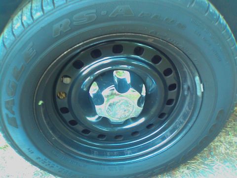 2000 Ford Crown Victoria - A close-up view of a black steel wheel with a chrome hubcap, fitted with an Eagle RS-A tire.