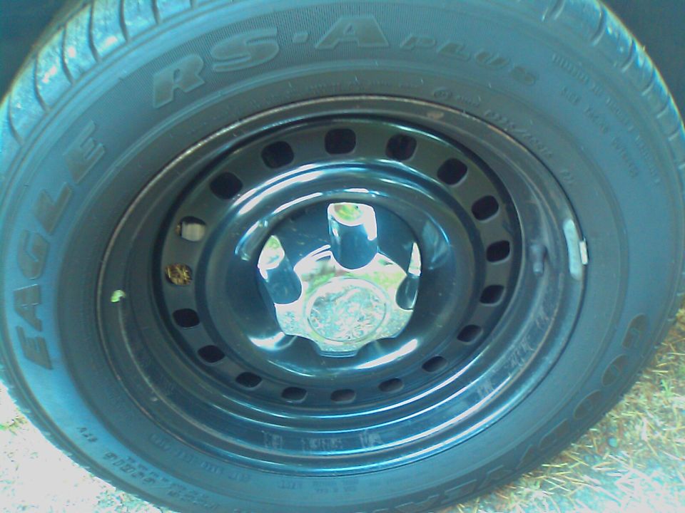 Close-up of a black steel wheel with a chrome hubcap and Eagle RS-A tire