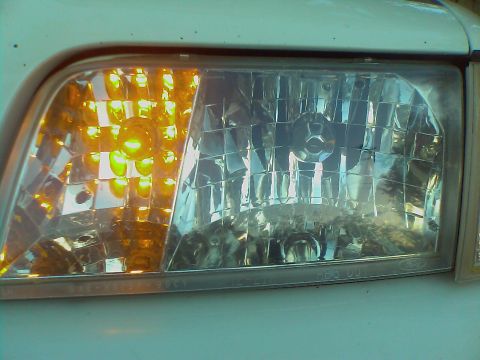 2000 Ford Crown Victoria - Headlight assembly detail from a 2000 Ford Crown Victoria, showing the turn signal and main beam reflectors.