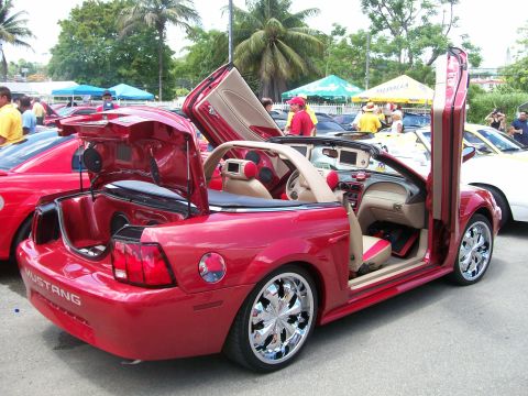 2001 Ford Mustang - This red 2001 Ford Mustang convertible features custom lambo doors and a unique interior with visible speakers.
