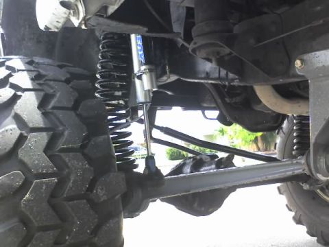 1995 Ford Bronco - Undercarriage view of a modified off-road vehicle's suspension system and tire.
