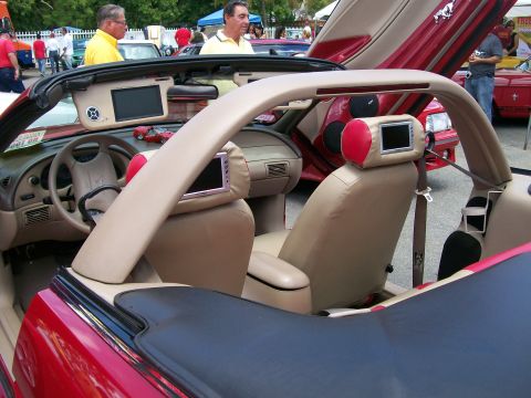 2001 Ford Mustang - This red 2001 Ford Mustang convertible features custom interior modifications including screens on the headrests and butterfly doors.