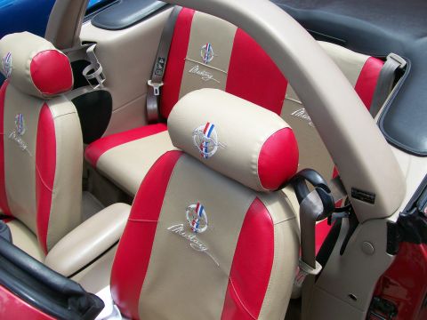 2001 Ford Mustang - Interior view of a 2001 Ford Mustang, showing custom red and tan seats with embroidered Mustang logos.