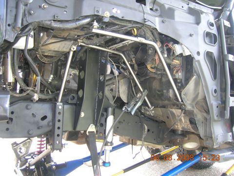 1996 Ford Bronco - The photo shows the complex undercarriage and engine bay of a vehicle, with visible suspension modifications and wiring harnesses.