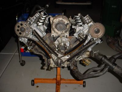 2007 Ford Mustang - A Ford V8 engine is shown on an engine stand, displaying its timing chain and alternator components.