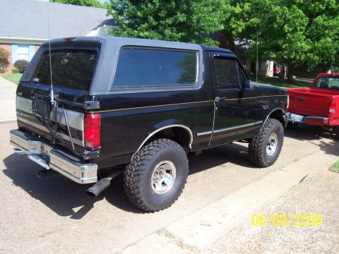 1994 Ford Bronco - Black 1994 Ford Bronco with a grey top and spare tire on the back.