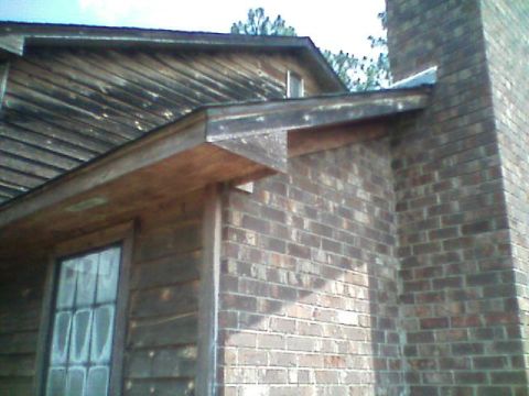 1992 Ford F-150 - The photo shows the exterior of a house, focusing on the brick chimney and wooden siding.