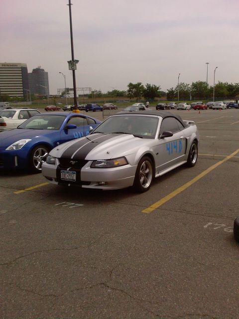 2001 Mercury Grand Marquis - Silver 2001 Ford Mustang convertible parked in a lot with other cars.