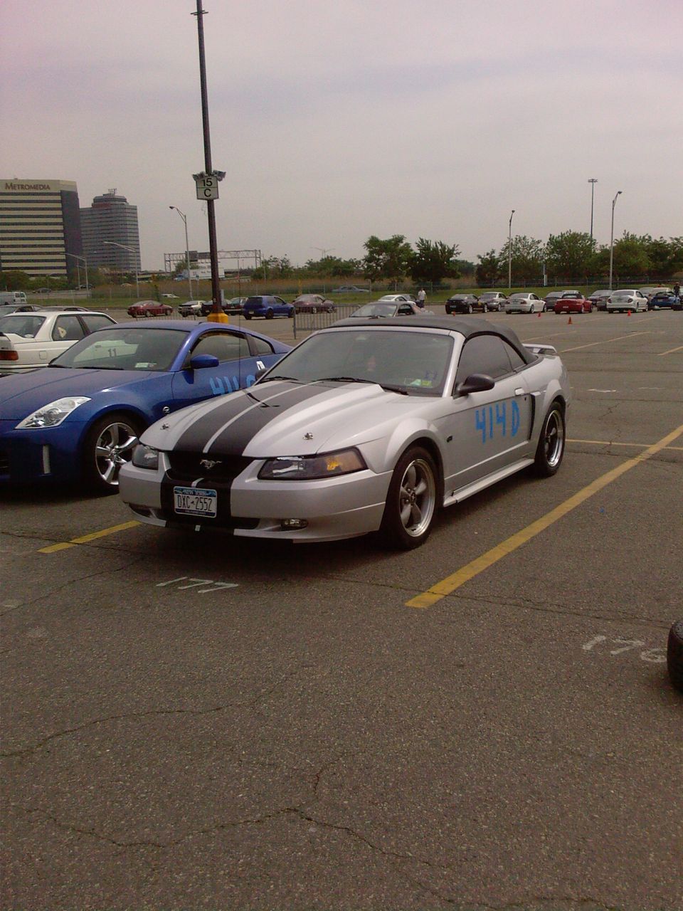Silver 2001 Ford Mustang convertible with black racing stripes and blue 414D markings on the side