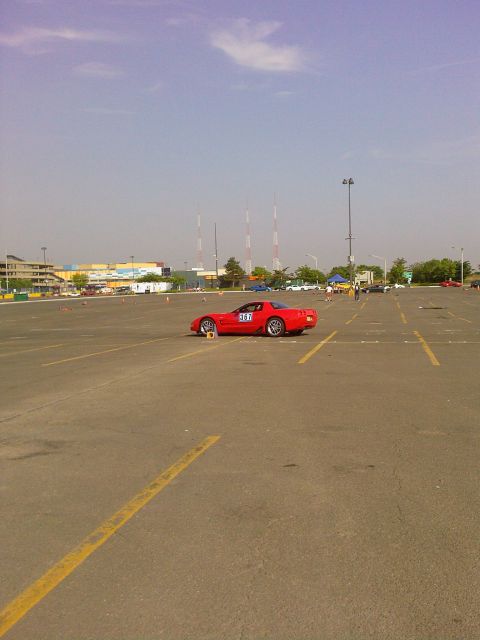 2001 Mercury Grand Marquis - A red sports car is parked on an asphalt lot marked with yellow lines, under a clear sky.