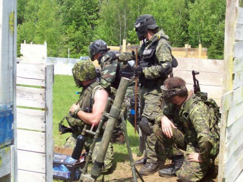 1985 Ford Bronco - Players in camouflage gear prepare for a paintball game, with one man holding a mortar.