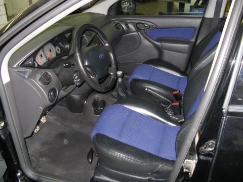 2003 Ford Focus - The interior of a 2003 Ford Focus shows its distinctive blue and black seats and dashboard layout.